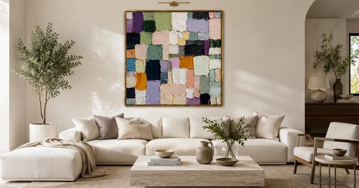 Large abstract colorful canvas painting hanging above a white modern sectional sofa.