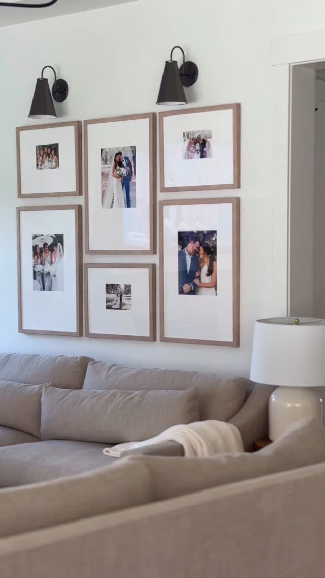 Six framed photographs arranged in a gallery wall above a grey couch.