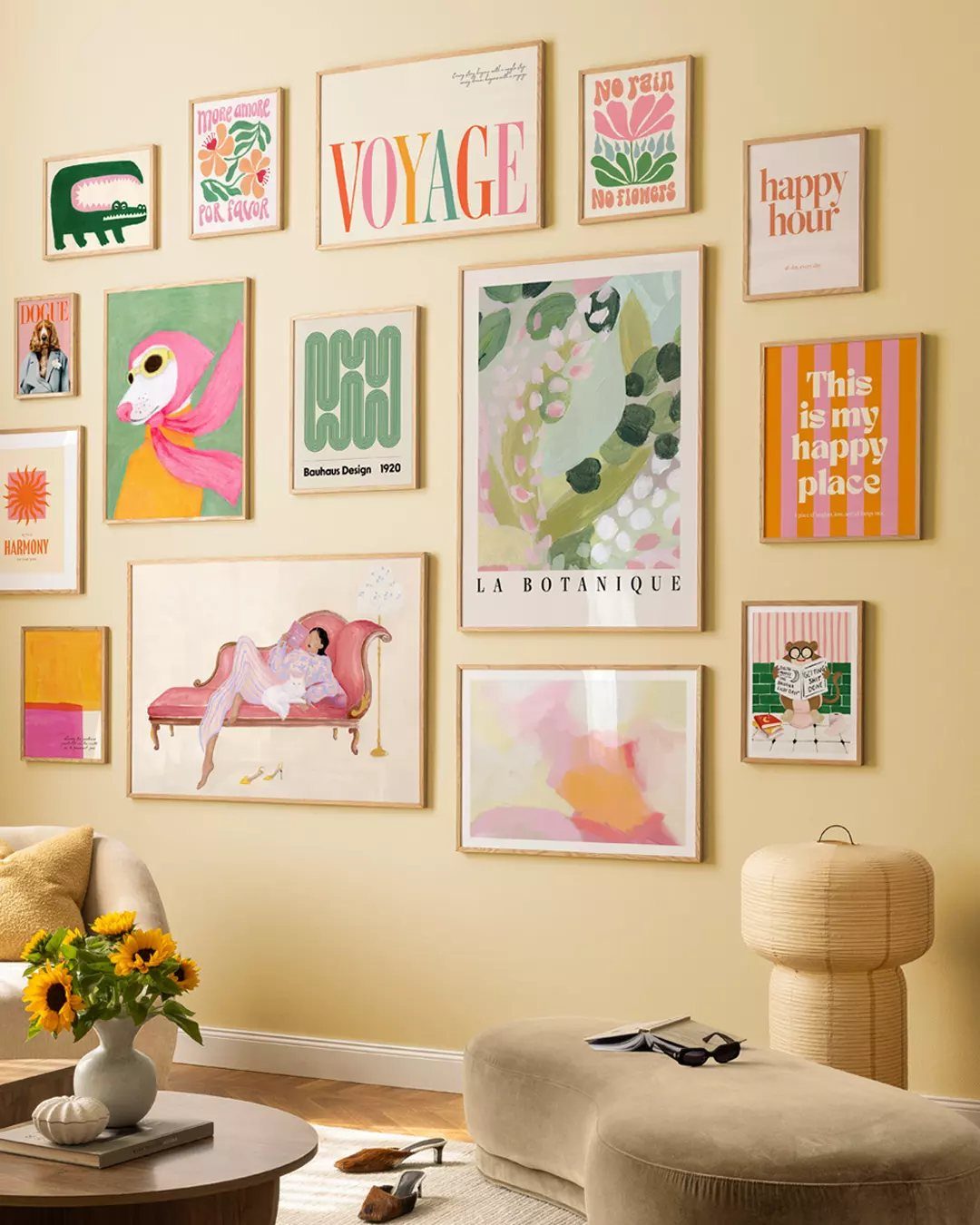 Eclectic gallery wall with colorful art prints on a pale yellow living room wall