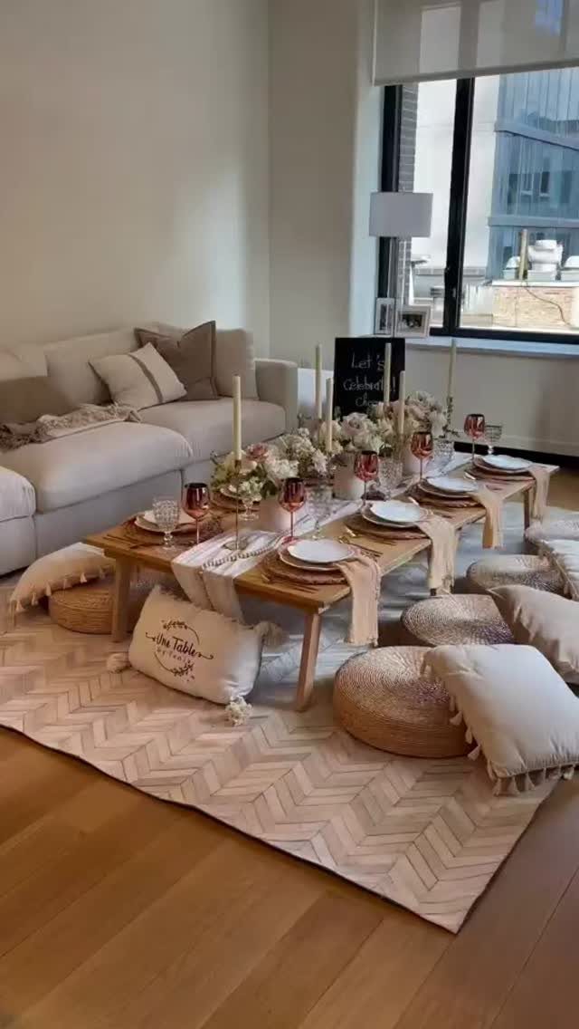 Woven jute poufs and cream fabric floor cushions around a low wooden table.