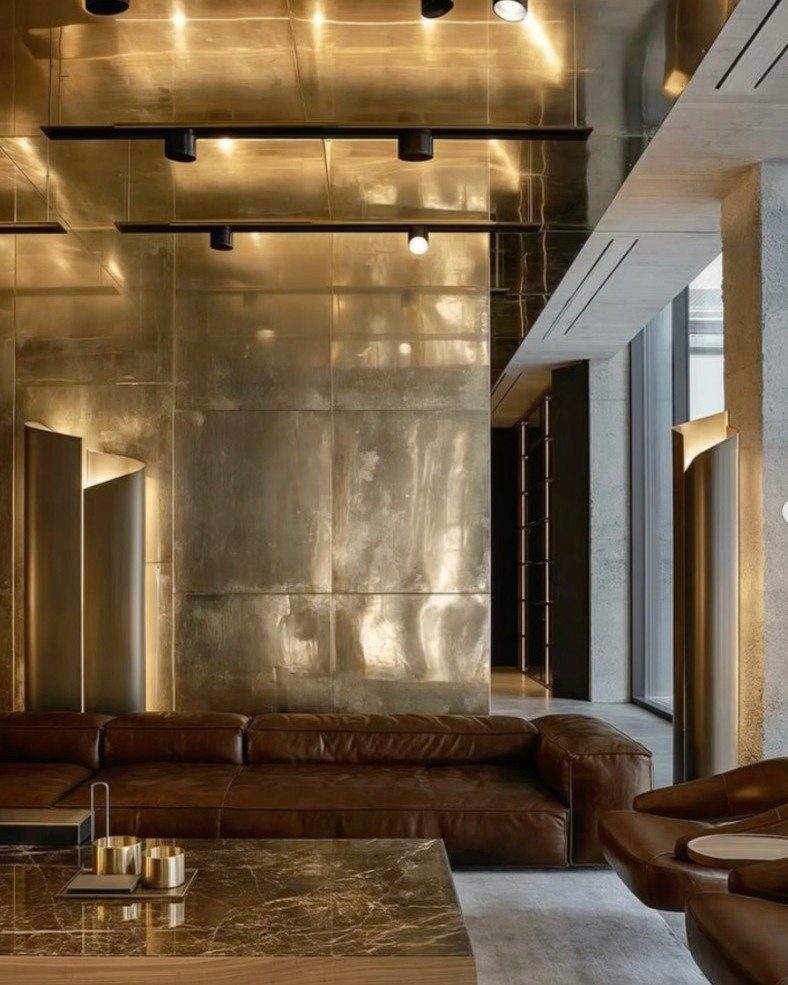 Brown leather couch in a modern living room with gold metallic walls.