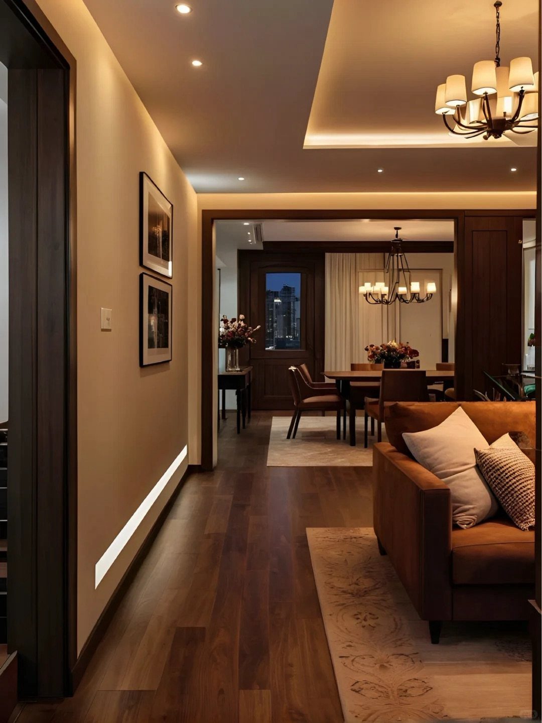 Brown leather couch in a room with recessed lighting and a chandelier.
