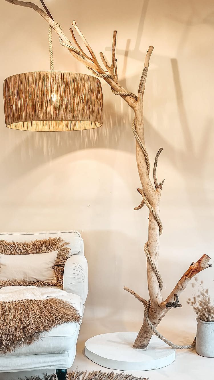 White armchair with shaggy brown textiles next to a natural branch floor lamp.