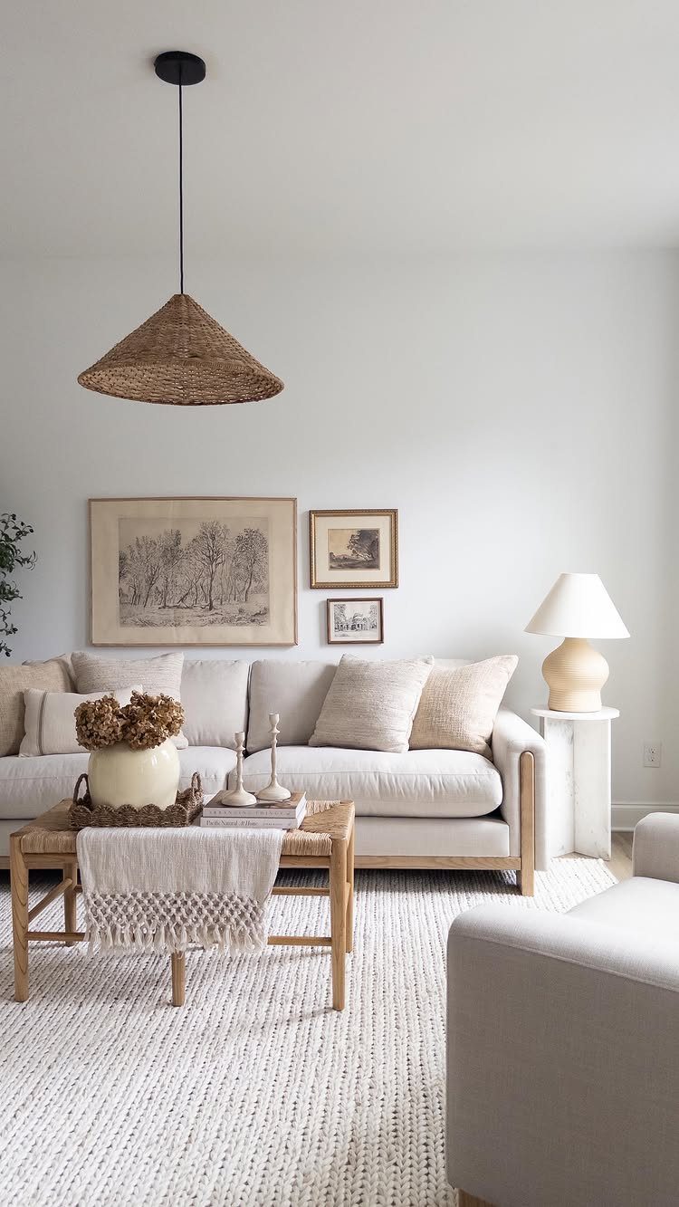 White slipcovered sofa and wooden coffee table in a neutral farmhouse living room.