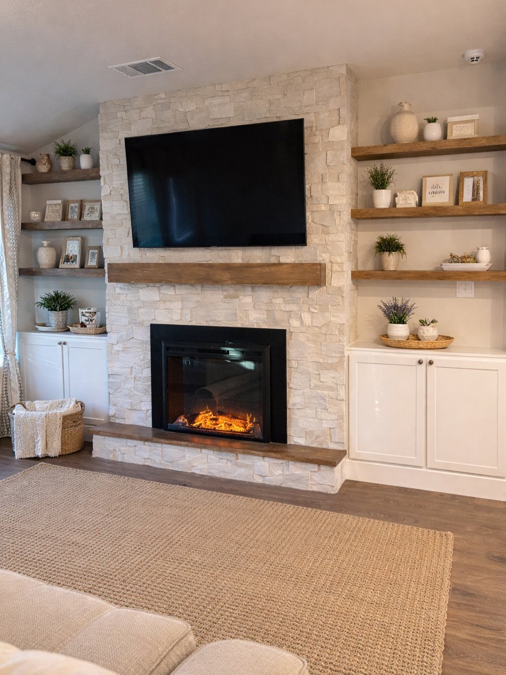 Flat-screen TV mounted above a wooden mantel on a white stone fireplace.