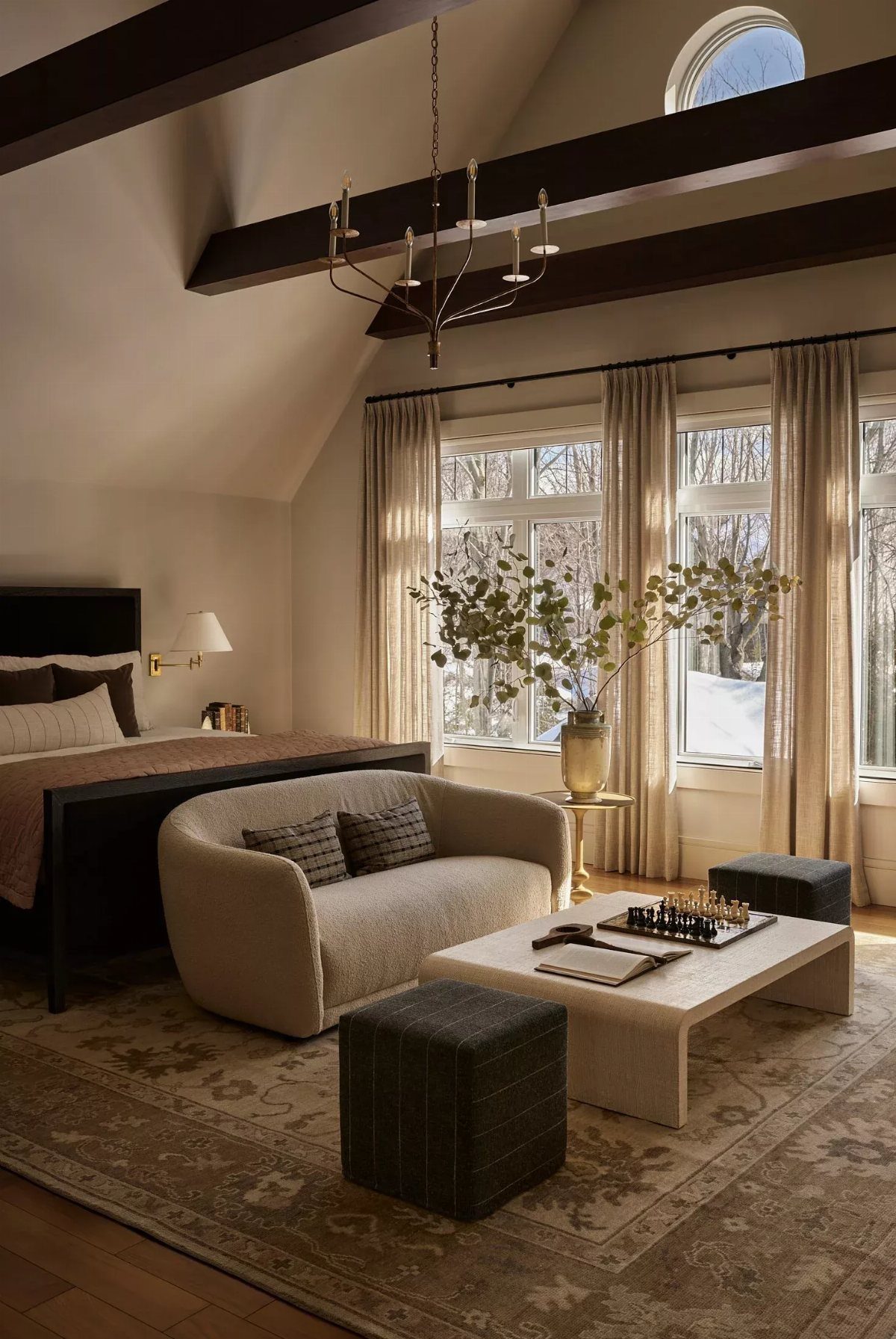 Cream curved sofa and coffee table creating a lounge area in a bedroom.