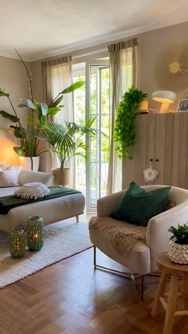 Living room with large green potted plants near a bright glass door.
