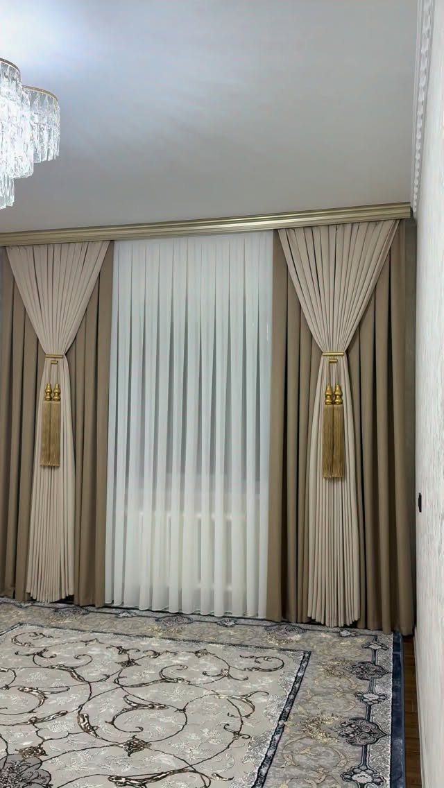 Beige and white curtains with gold tassel tie-backs in a living room setting