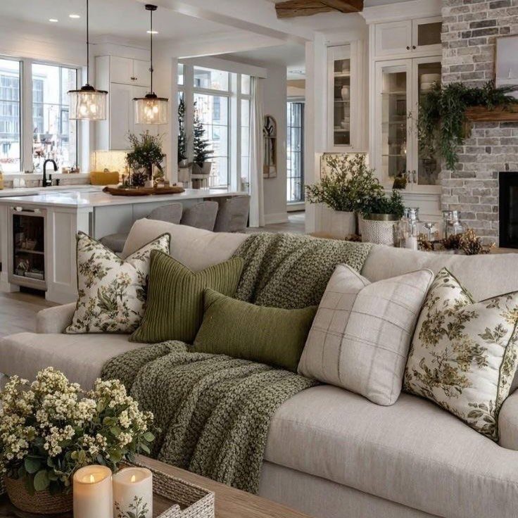 Cream sofa with green botanical pillows in a rustic farmhouse living room setting