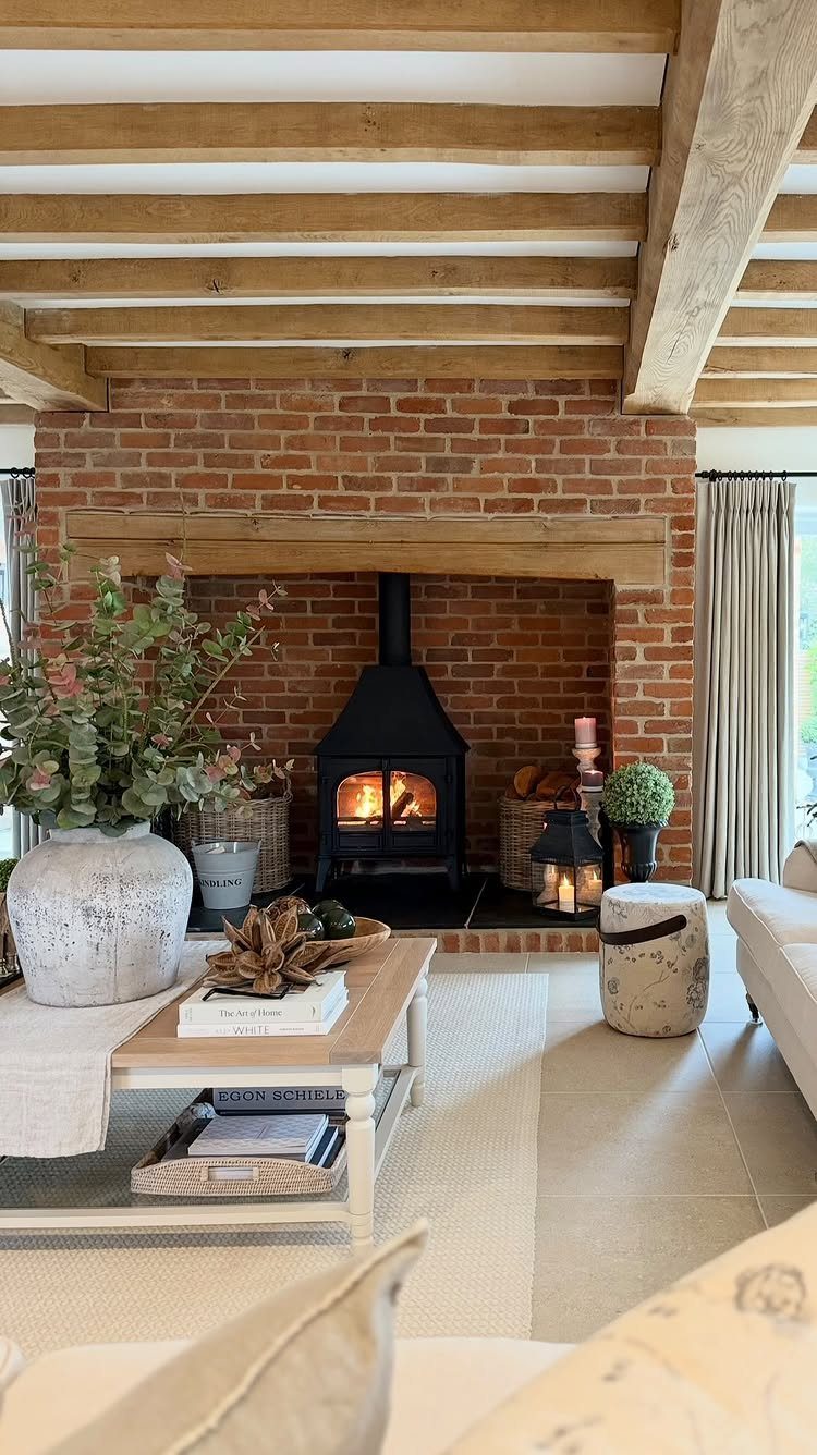 Wooden exposed ceiling beams above a brick fireplace in a rustic living room.