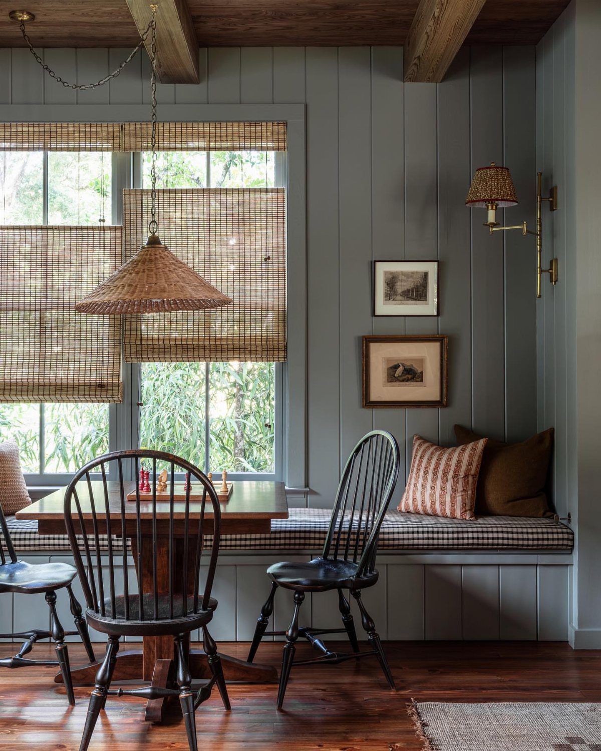 Built-in window bench with checkered cushions in a rustic dining room setting.