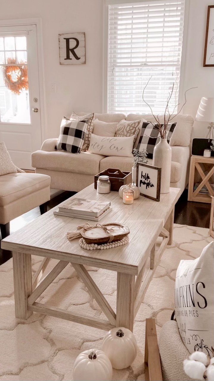Farmhouse living room featuring a light wood coffee table and decorative wall signs.