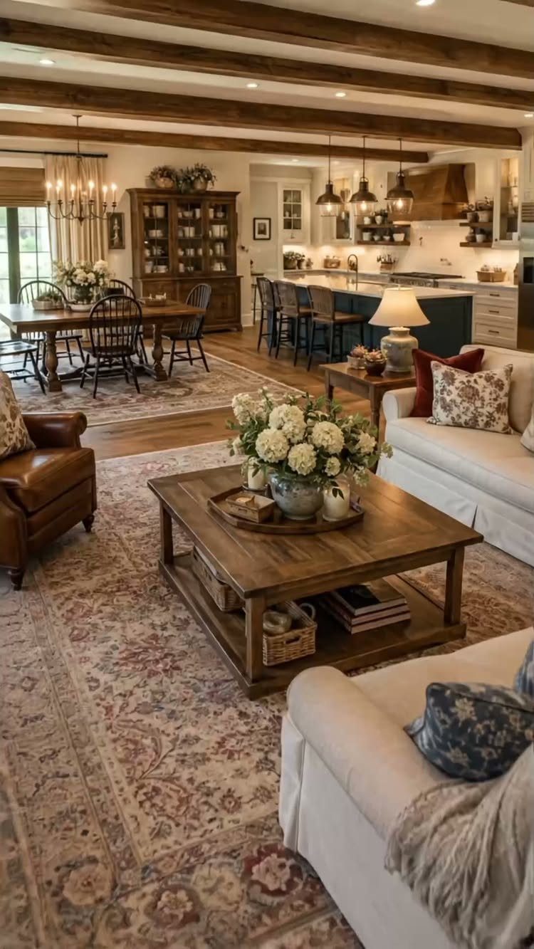 Farmhouse living room with wooden beams, slipcovered sofas, and a rustic wooden coffee table.