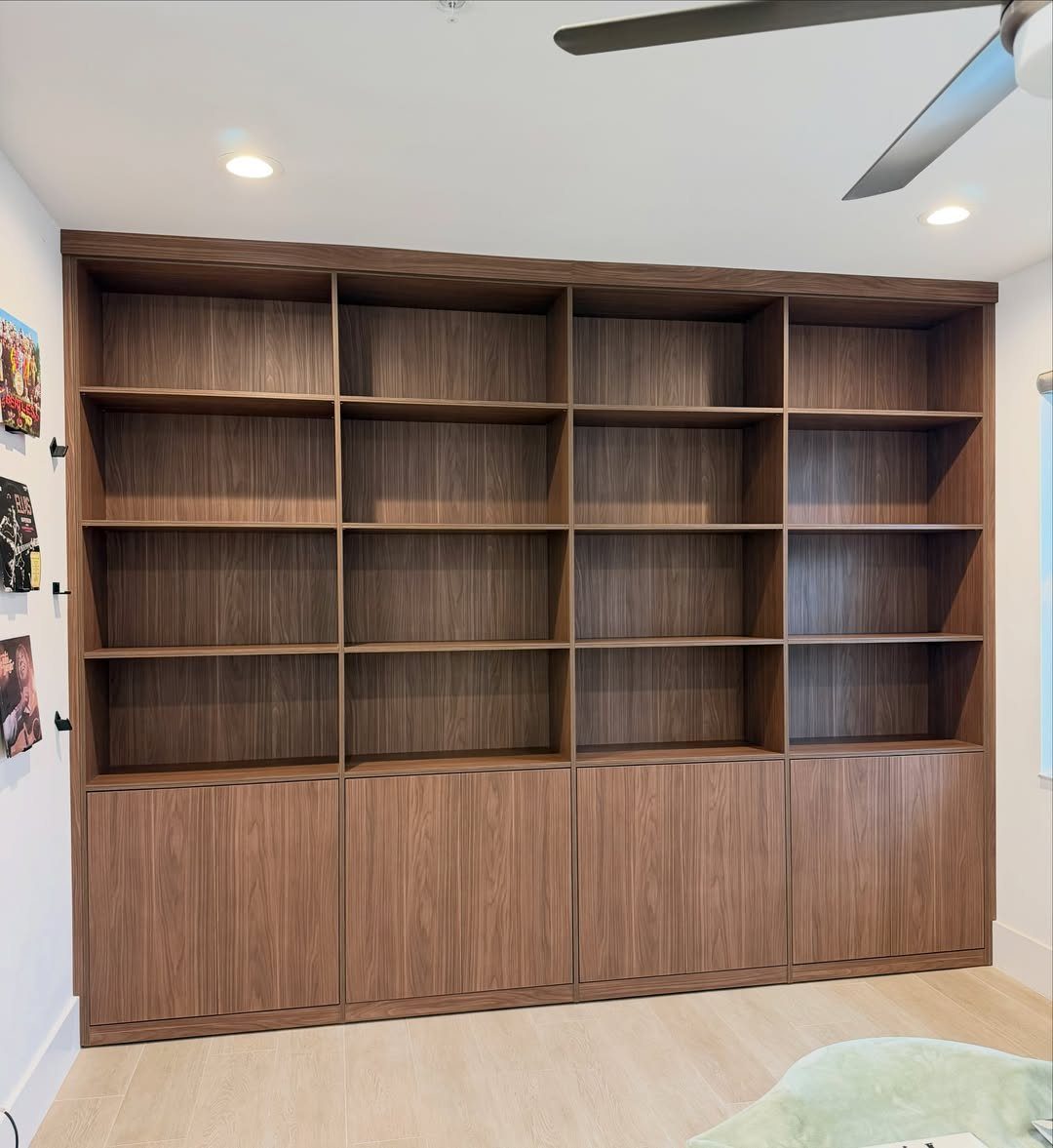 Dark wood built-in cabinets and shelving unit against a white interior wall.