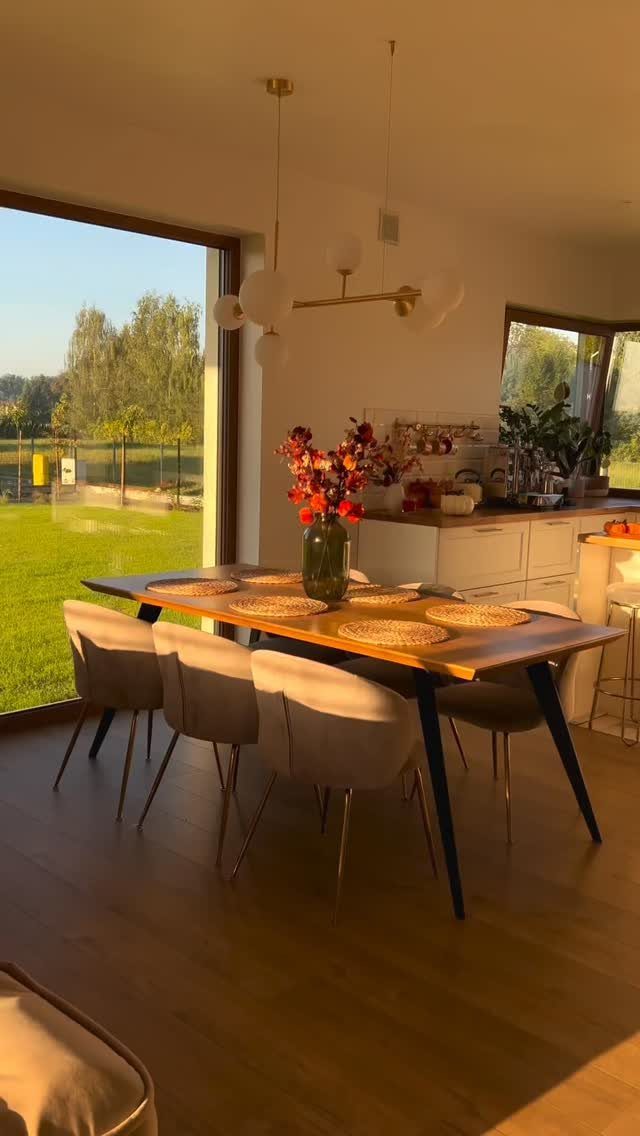 Dining room with a wooden table and large glass door opening to outdoors.