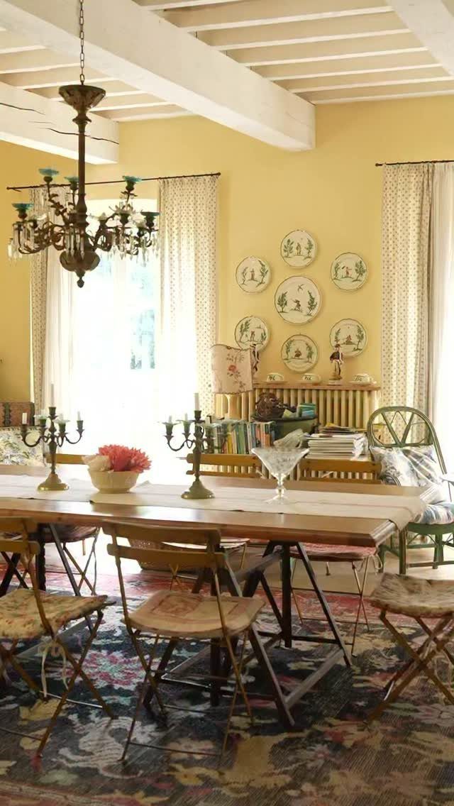 Dining room with yellow walls, decorative plates, and a rustic wooden table.