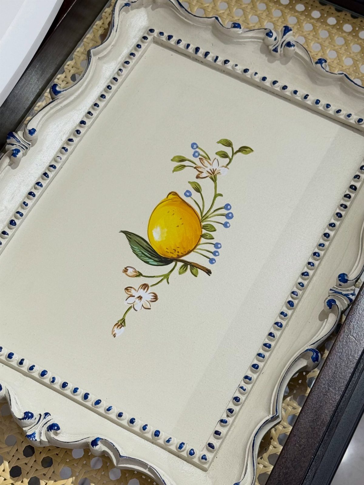 Ceramic decorative tray with a painted lemon and blue scalloped edges.