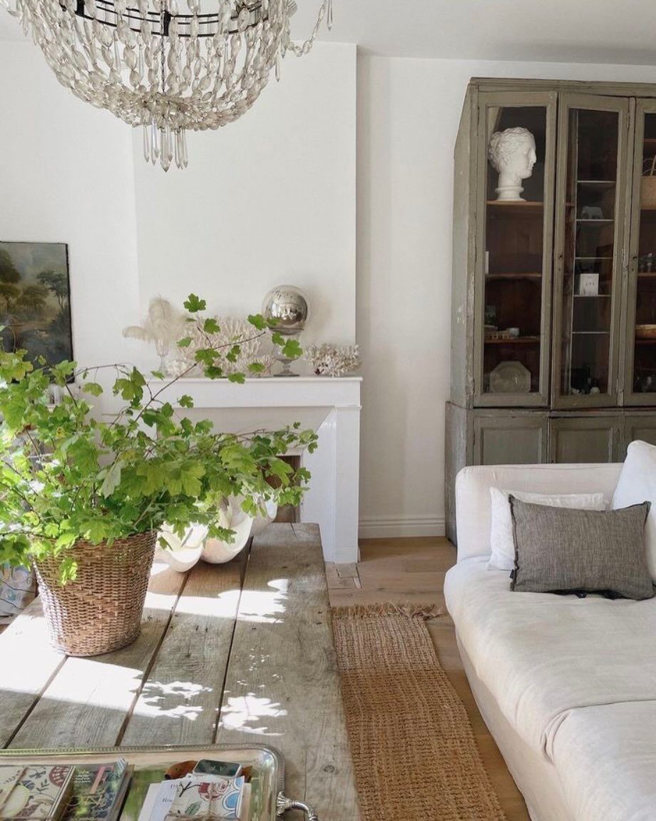 Bright living room with white sofa, rustic wooden table, and neutral toned decor.