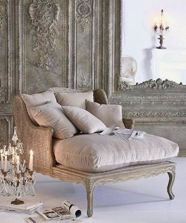Beige chaise lounge in a room with ornate grey carved wall panels