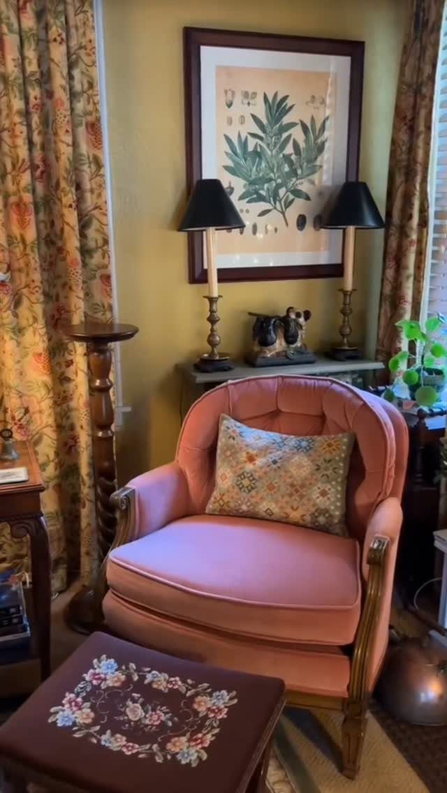 Pink velvet vintage armchair with a floral pillow in a French country living room.