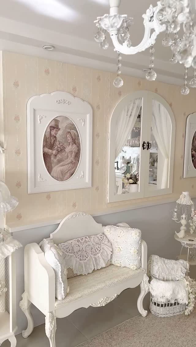 Ornate white frame with a vintage portrait hanging above a white lace settee.