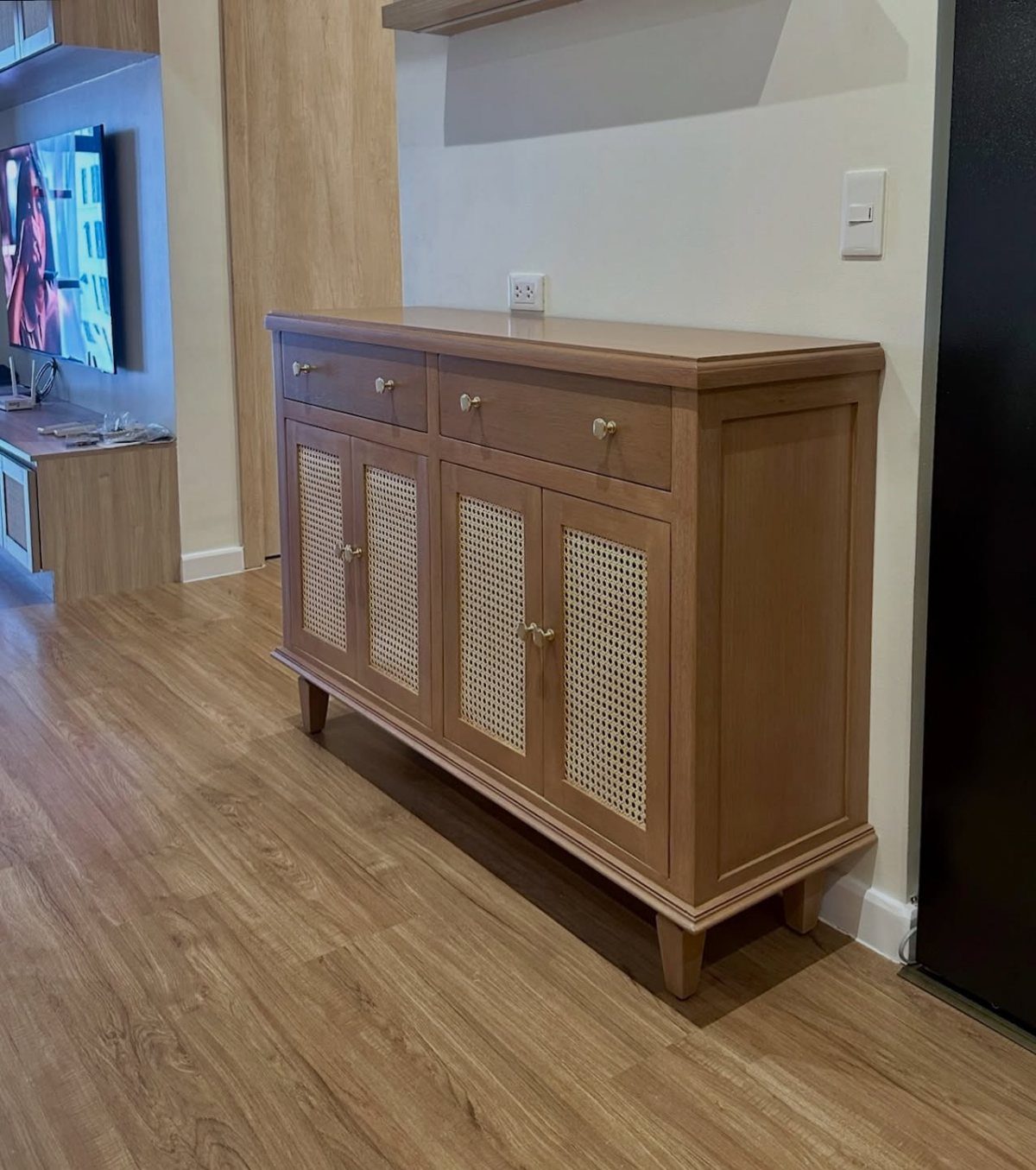Wooden sideboard with cane doors in a living room with wood flooring