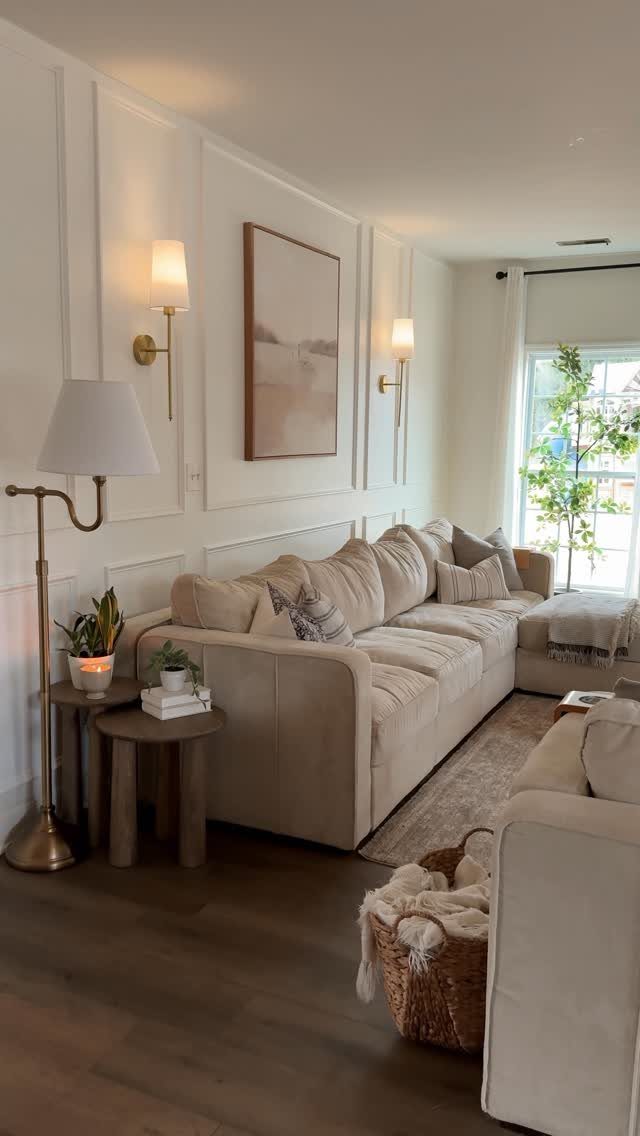 Beige sectional sofa in a small living room with white paneled walls.