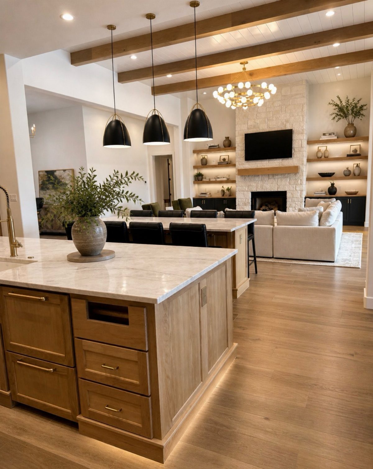 Open concept room with kitchen island leading to a living area with fireplace.