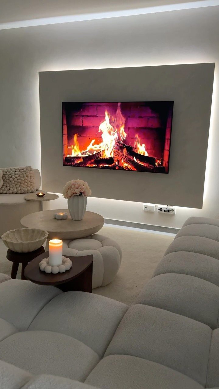 Modern living room with white modular sofa and digital fireplace on a grey wall