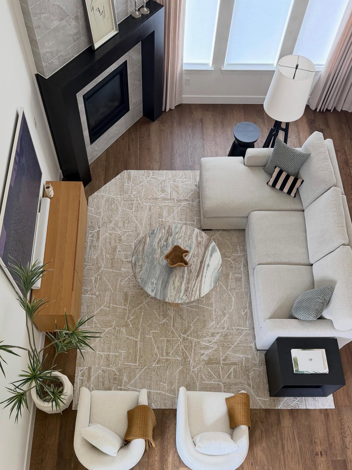Living room furniture arranged around a black fireplace with a white sectional sofa.
