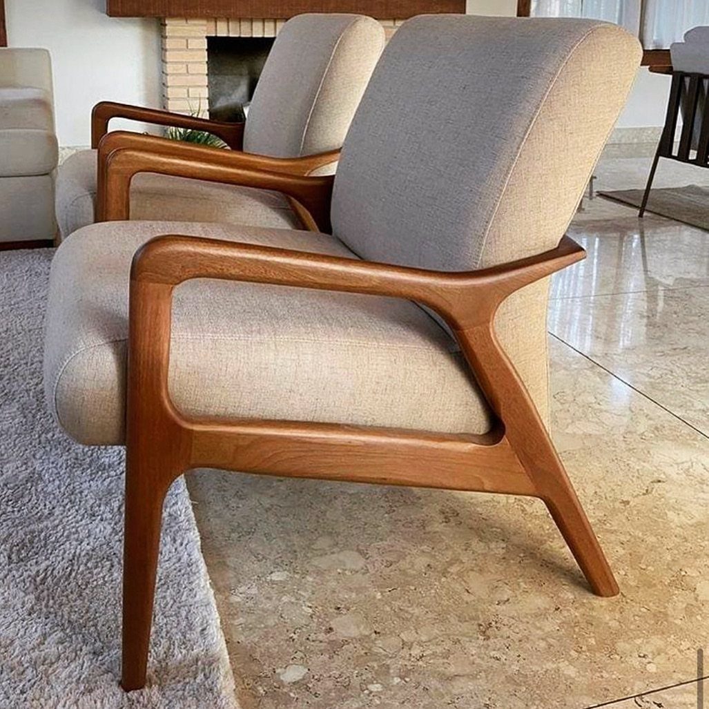 Two mid-century modern accent chairs with beige fabric and curved wooden frames.
