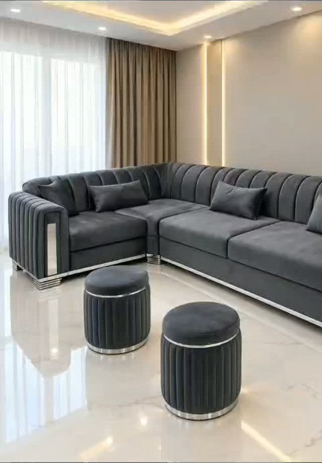 Dark grey sectional sofa with silver trim and matching ottomans in modern living room