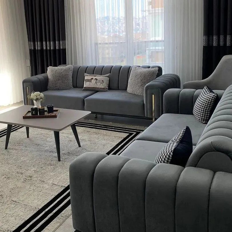 Grey channel-tufted sofas with gold accents and a modern coffee table in living room