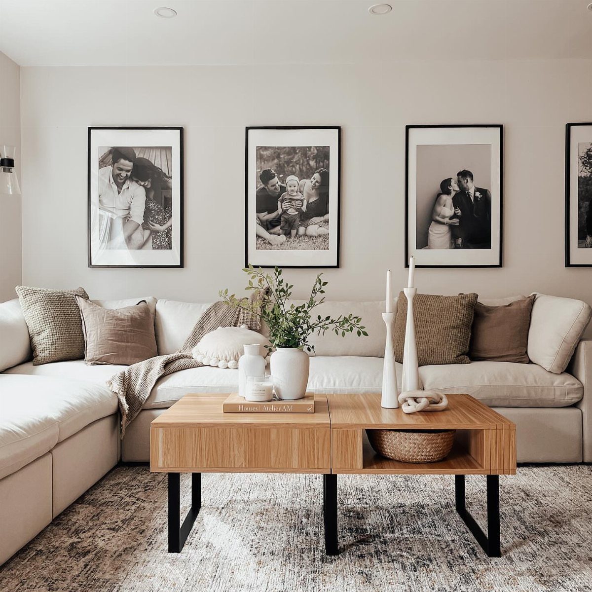 Black framed photos hanging at a consistent height above a white sectional sofa.
