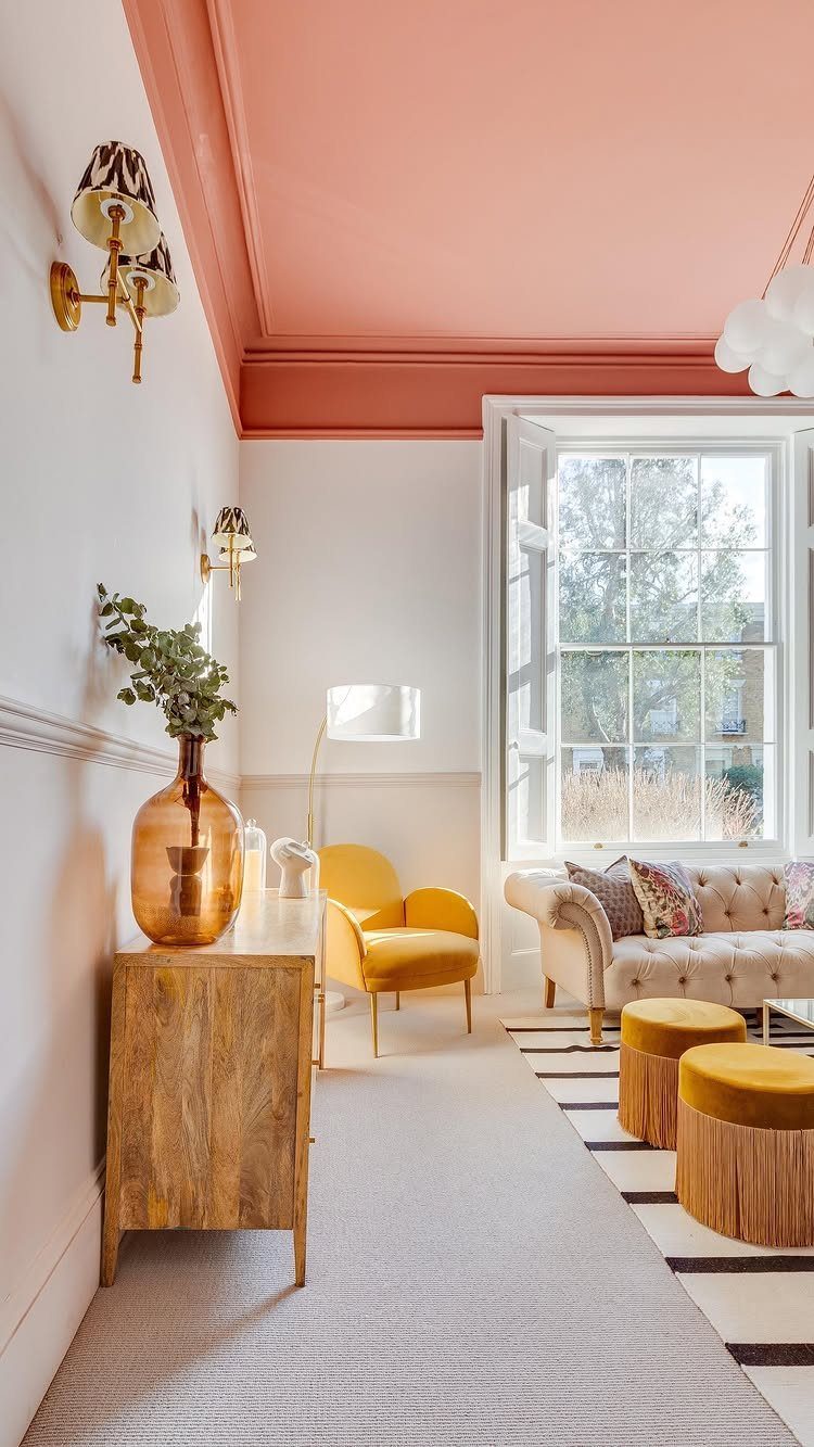 Living room with a peach ceiling contrasting against white walls and yellow furniture.