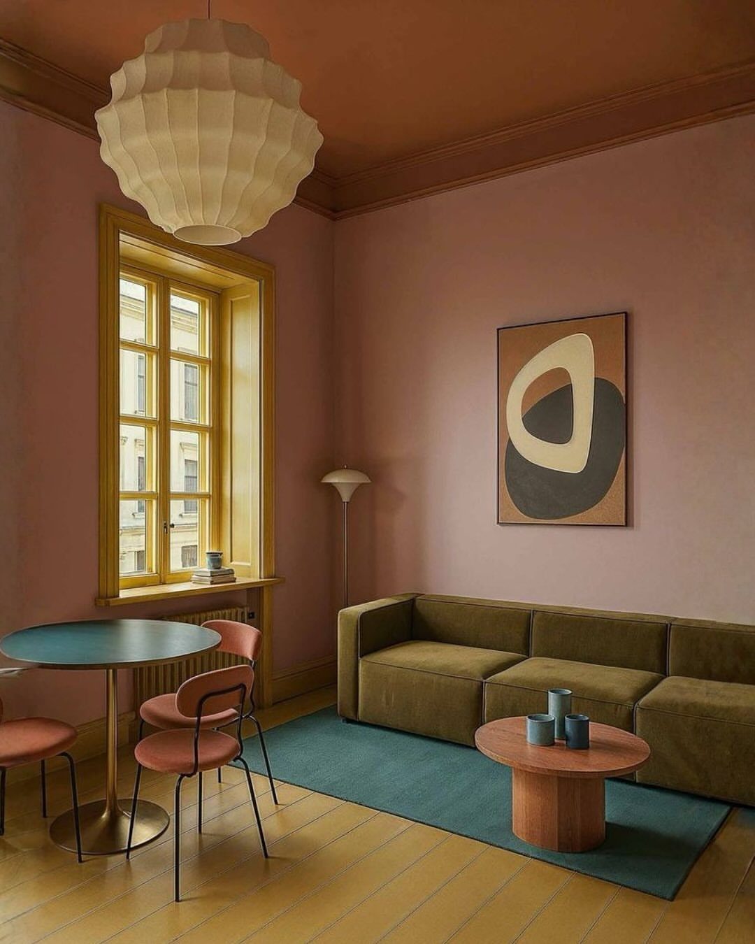 Mauve walls and terracotta ceiling in a high ceiling living room with modern furniture