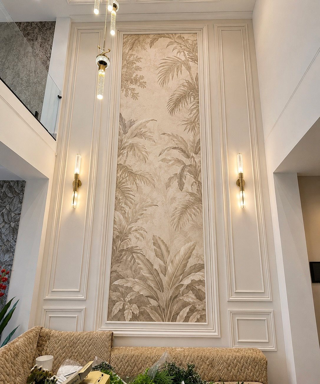 Tropical leaf mural on a tall wall panel with white molding and gold sconces