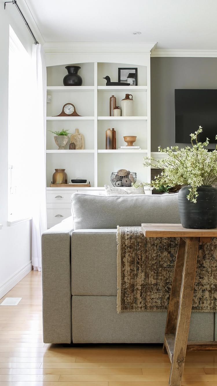 Grey sofa with a brown patterned blanket draped over the back in a living room