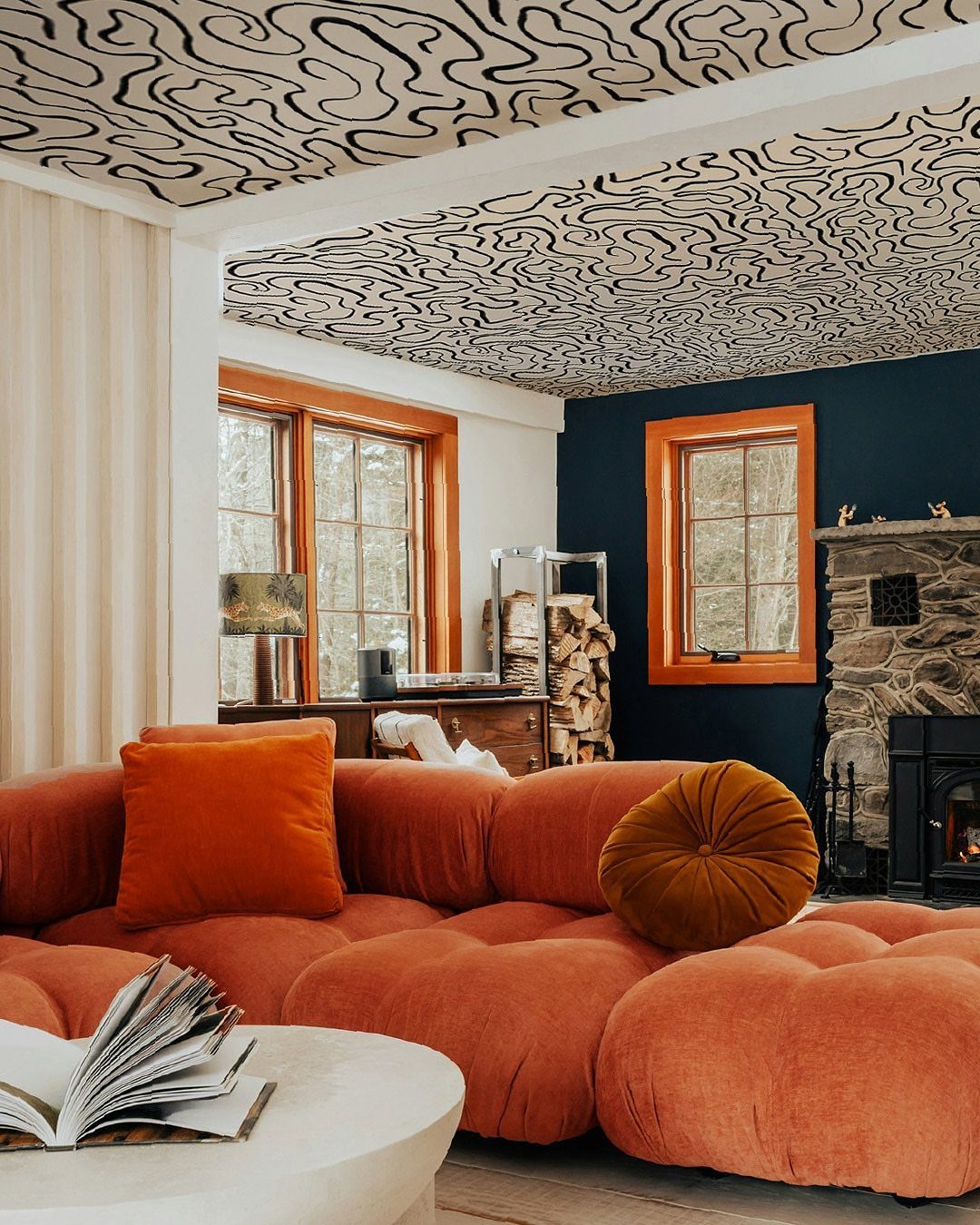 Plush orange modular sofa in a room with a patterned ceiling and blue wall.