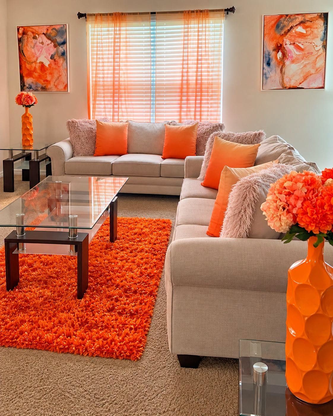 Living room with beige sofas and bold orange accents on rug and pillows