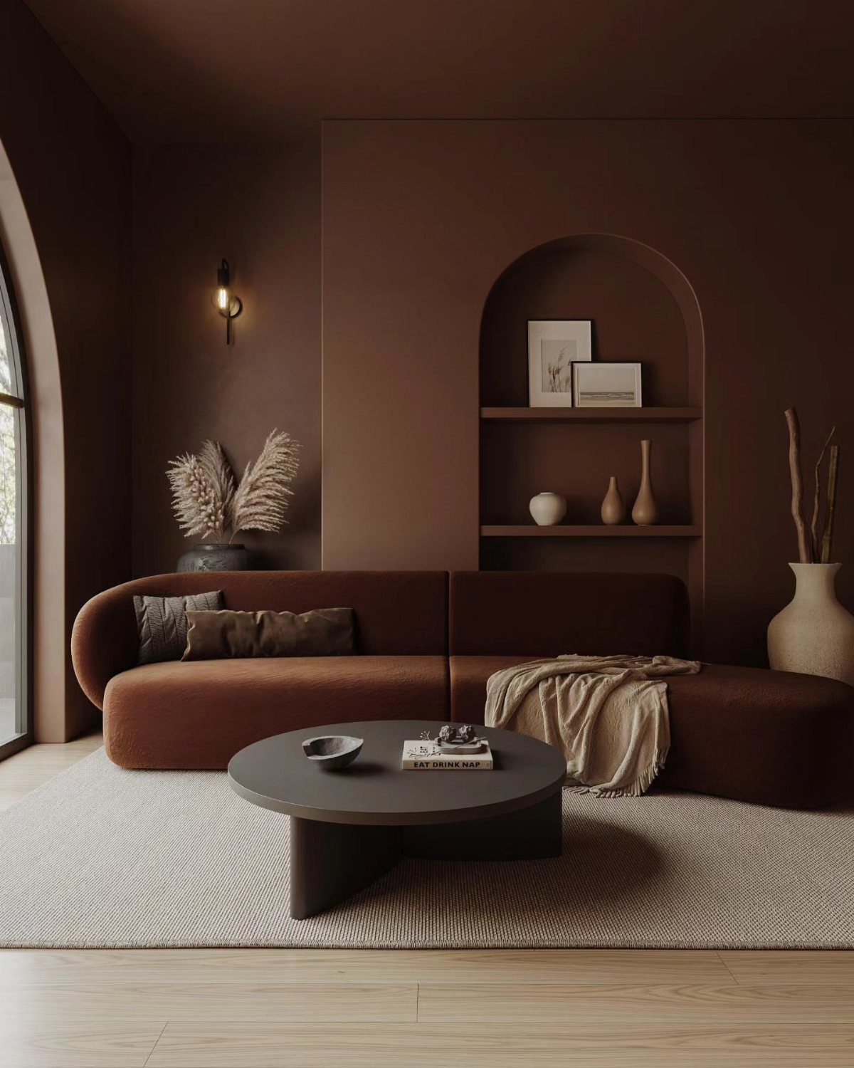 Umber brown living room with a curved sofa, black coffee table, and arched shelving.