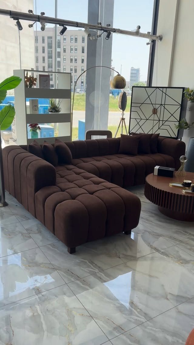 Brown modular sectional sofa in a modern living room with marble floors.