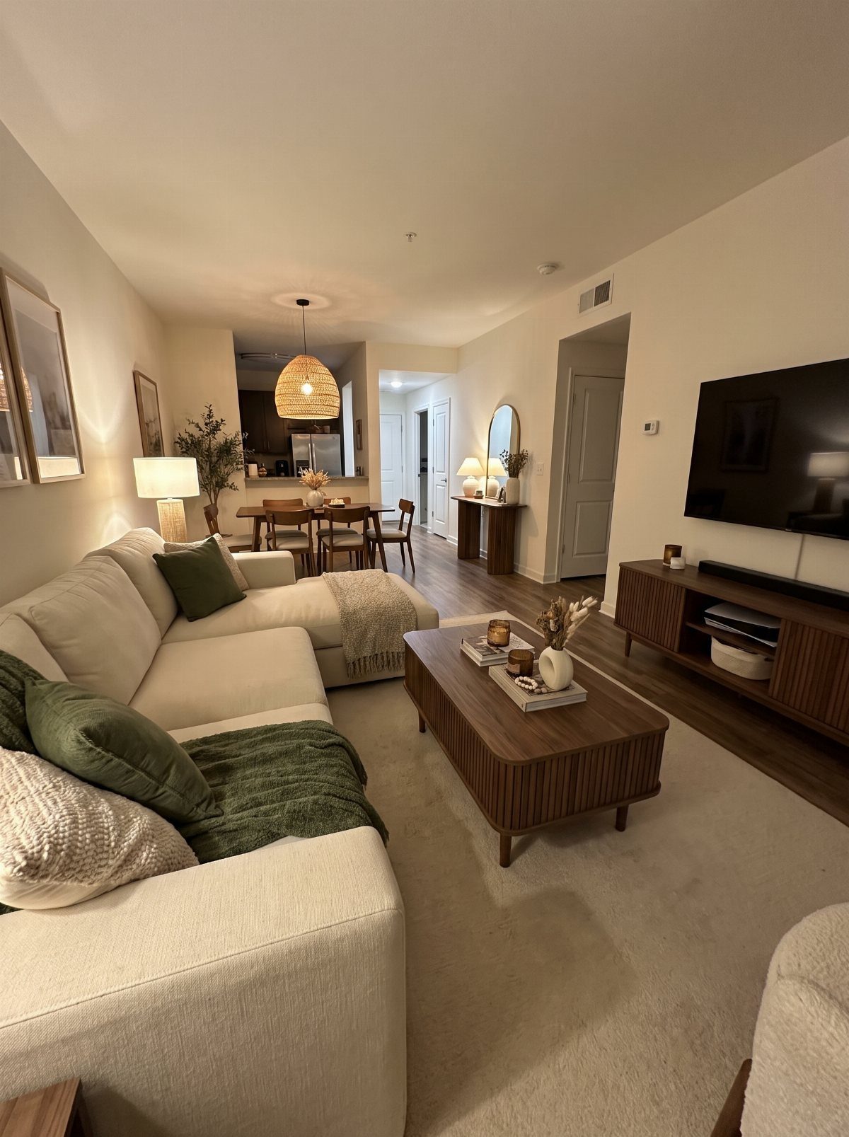 Cream sectional sofa with green pillows and wooden coffee table in cozy living room