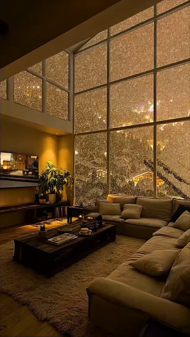 Beige L-shaped sofa and dark coffee table in a warm, rainy living room