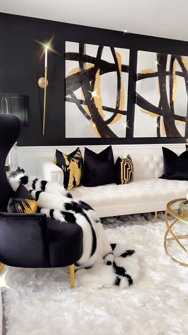 Luxurious living room with white tufted sofa, black velvet chair, and gold accents.