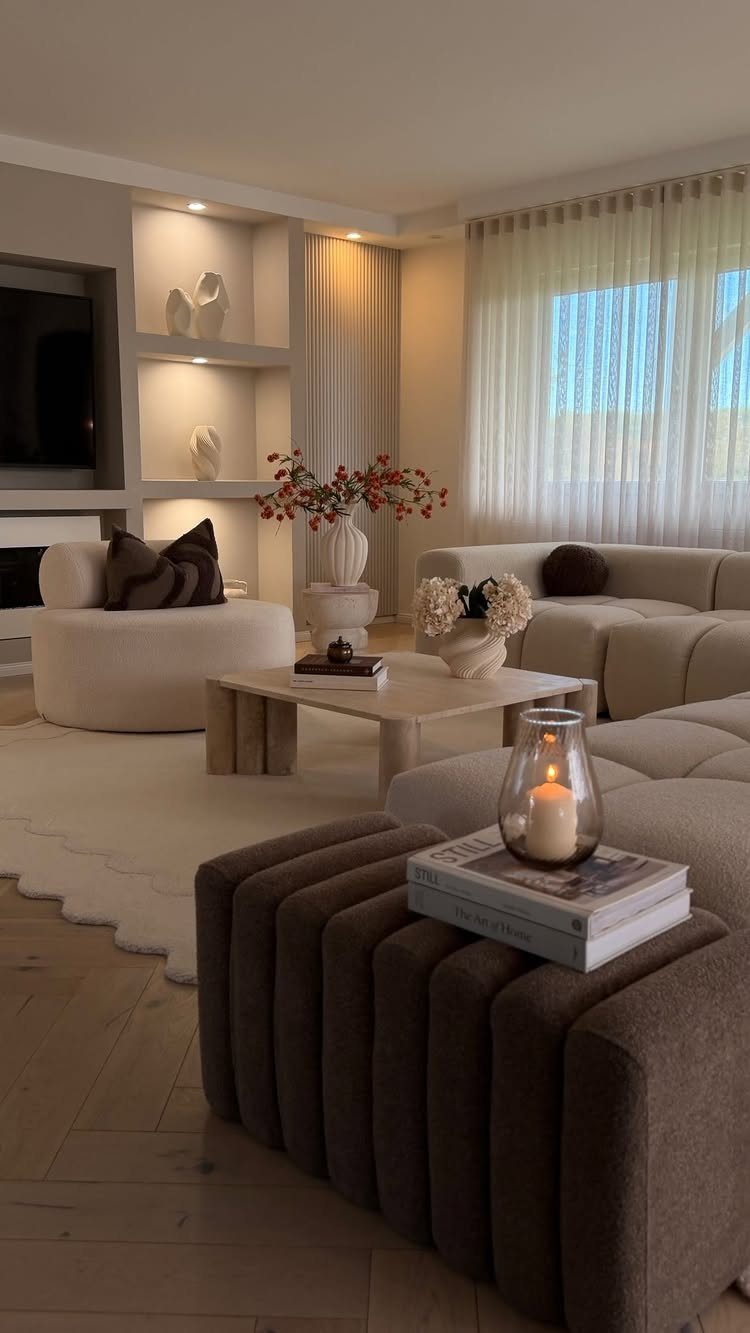 Modern living room with neutral beige furniture, stone coffee table, and warm lighting.