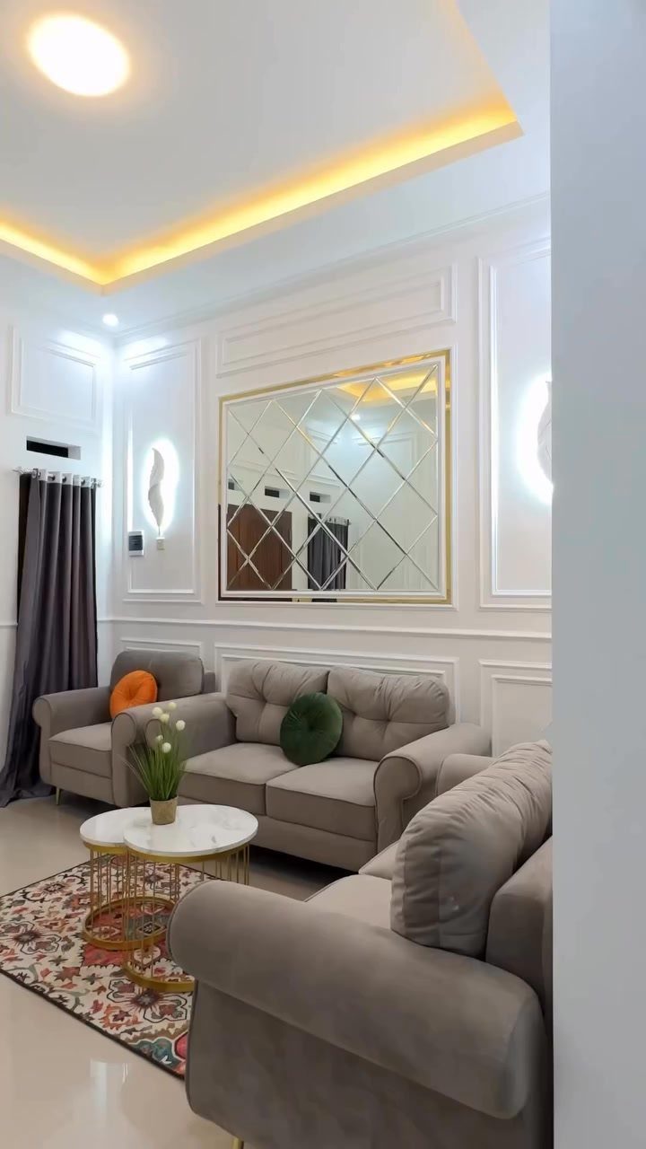 White walls with decorative mouldings in a modern living room with grey sofas.