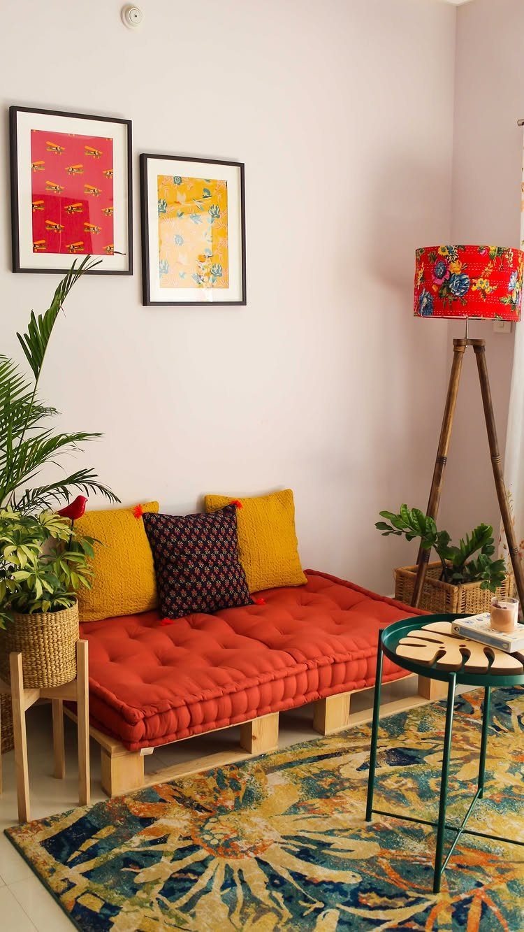 Red tufted floor sofa and colorful patterned rug in a small living room