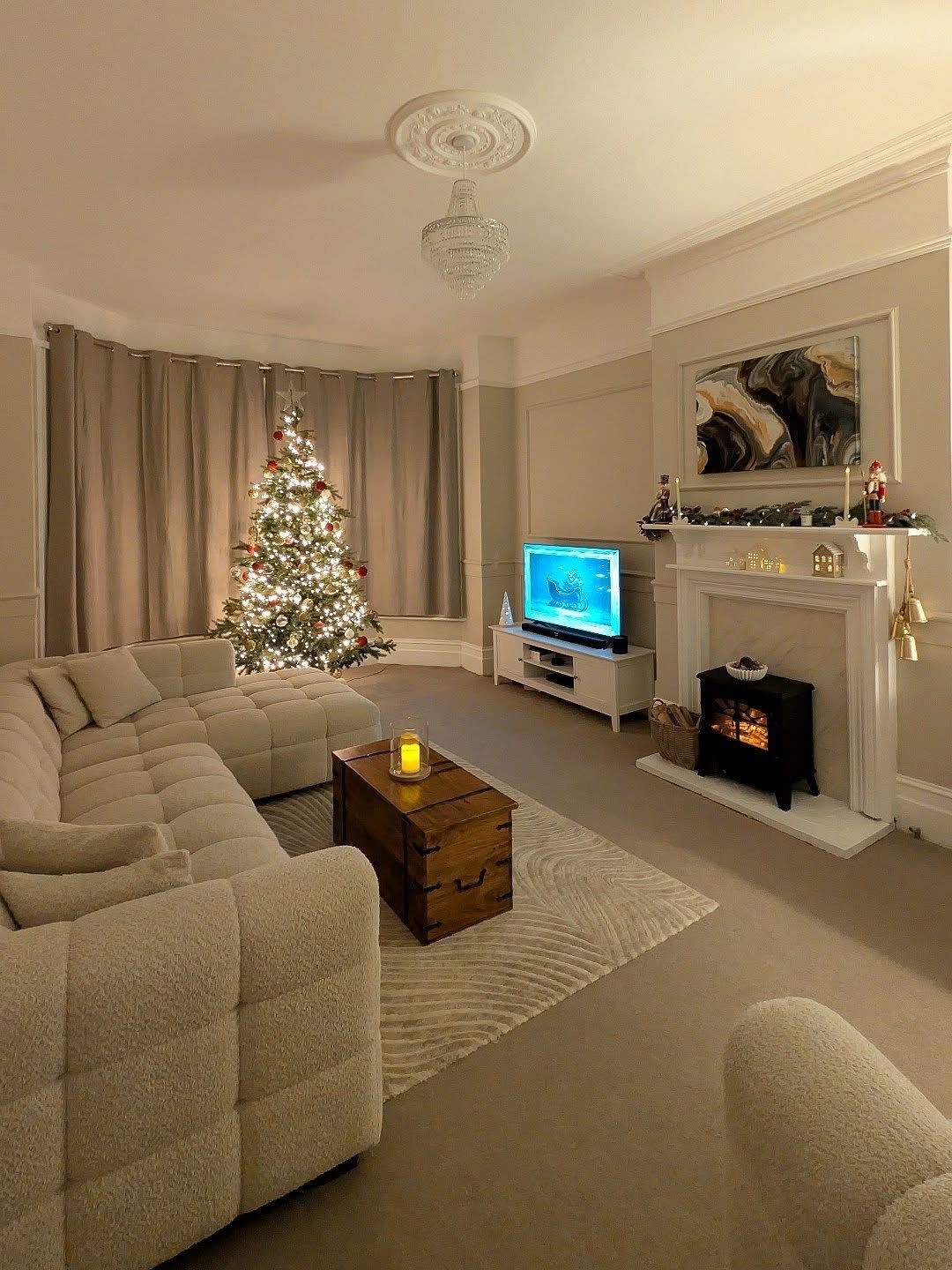 Beige sectional sofa and wooden coffee table facing a white fireplace with stove.