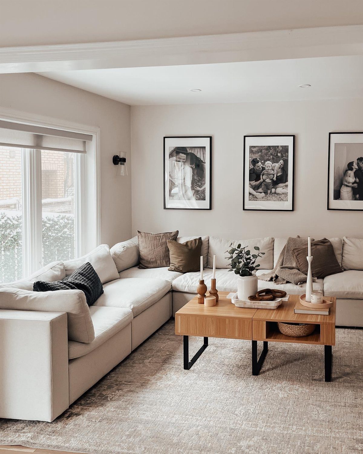 Large white sectional sofa and wooden coffee table on a grey area rug